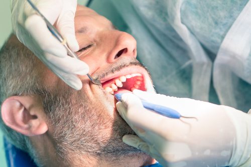 Male,Patient,Suffering,During,Dental,Hygiene,At,Dentist,Office,-