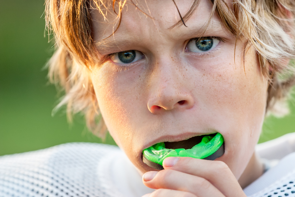 kid playing football with mouth guard