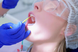 woman receiving fluoride treatment after dental cleaning