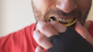 man putting in recreational athletic mouth guard