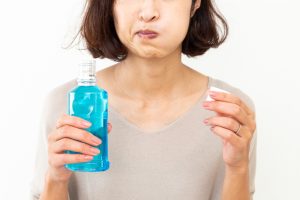woman using mouthwash