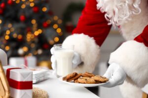 santa holding milk and cookies
