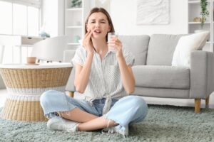 woman with sensitive teeth drinking cold milk